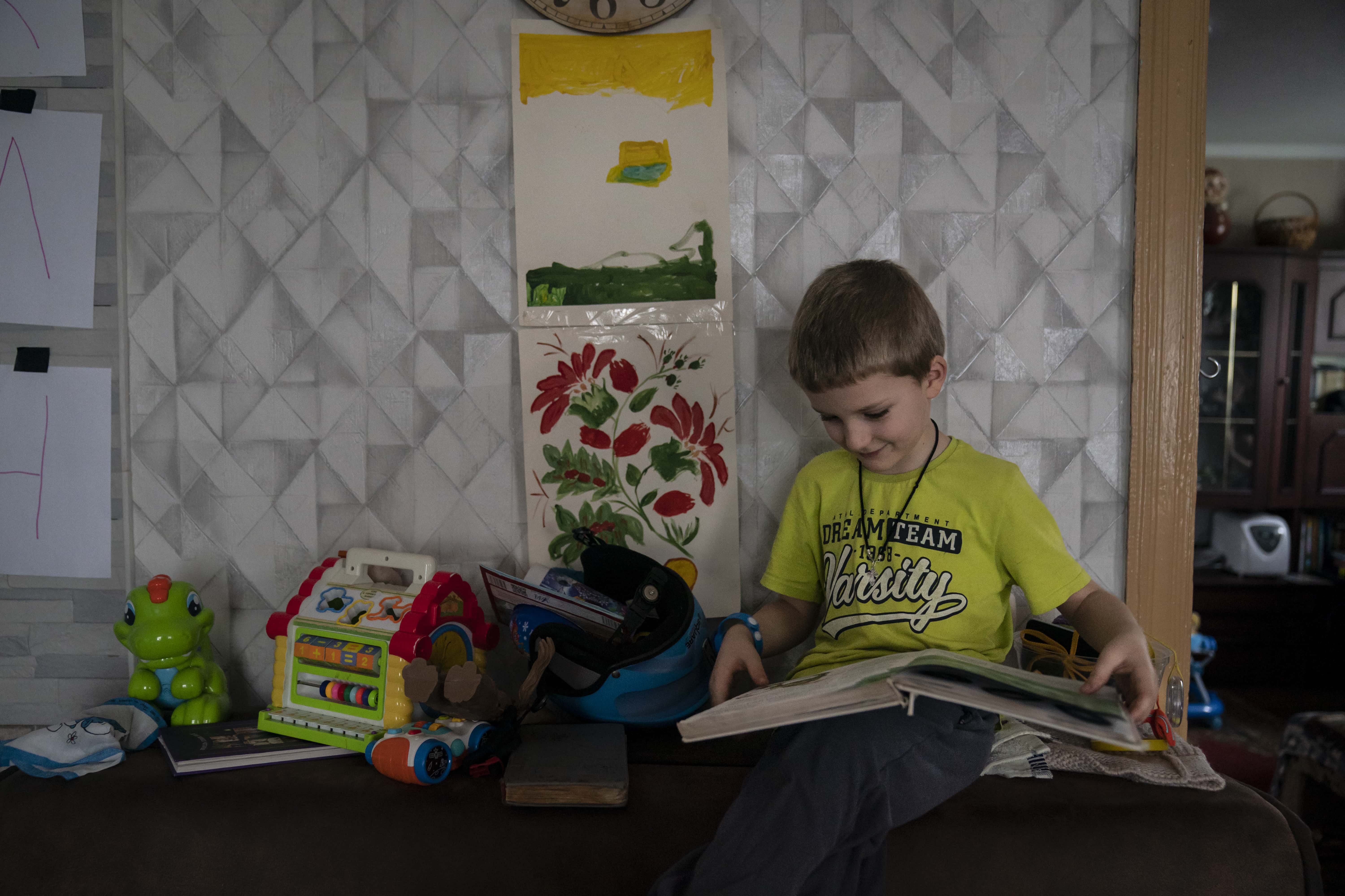 Ukraine_Ivan-5-looks-at-book-in-great-grandparents-home